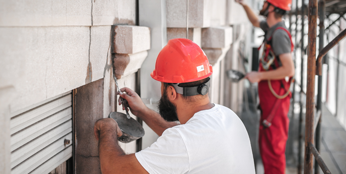 SGM-Handwerker restaurieren detailgetreu die Fassade eines denkmalgeschützten Gebäudes, um es originalgetreu zu renovieren.