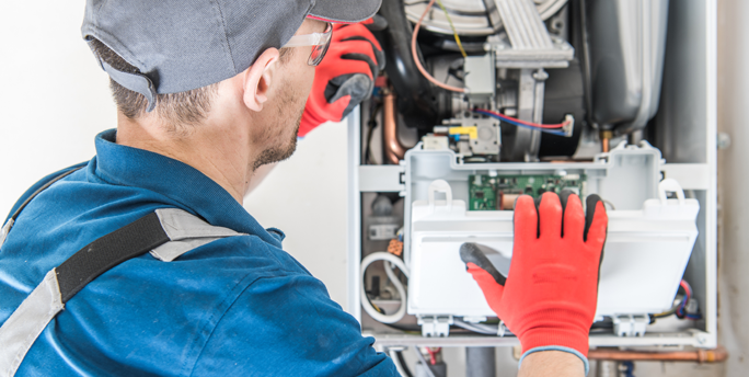 SGM-Techniker arbeitet an einer Gasheizung, um die Leistungen durch fachmännische Wartung zu sichern.