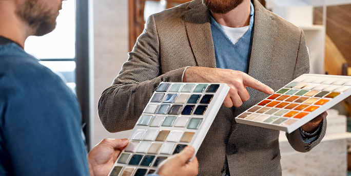 SGM-Experte berät einen Kunden zur Mosaik-Auswahl und zeigt verschiedene Designs für deren Renovierungsprojekt.